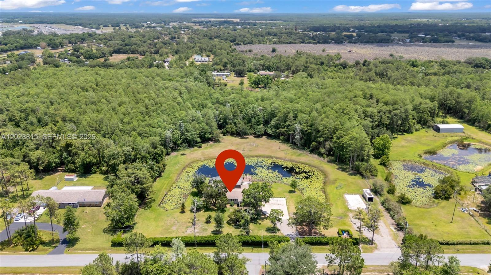 An aerial view shows a house situated on a lot with a pond and trees — 4125 rambler avenue, Saint Cloud FL 34772, SAINT CLOUD, FL