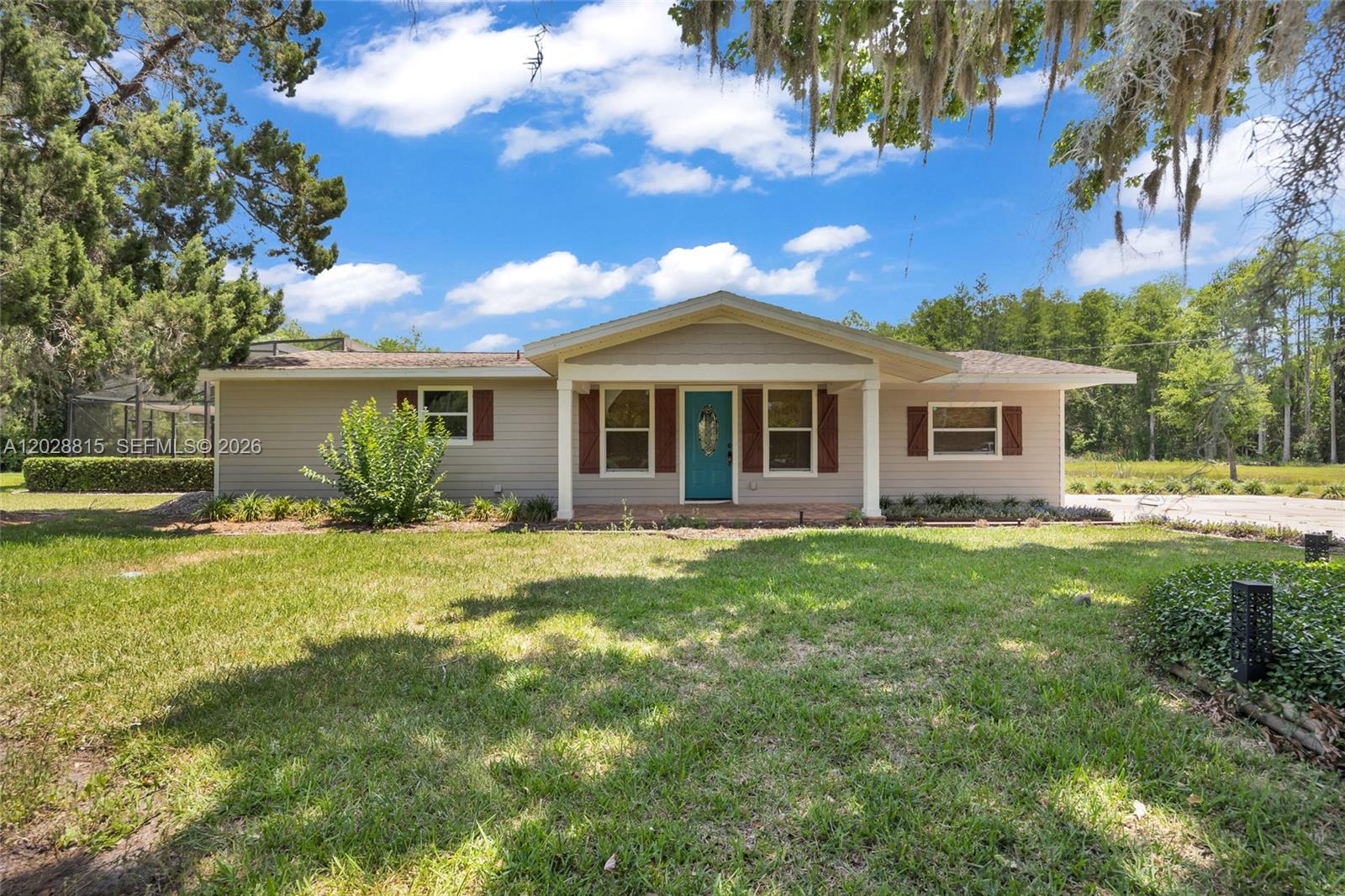 A single-story house with beige siding, a teal front door, and brown shutters — 4125 rambler avenue, Saint Cloud FL 34772, SAINT CLOUD, FL