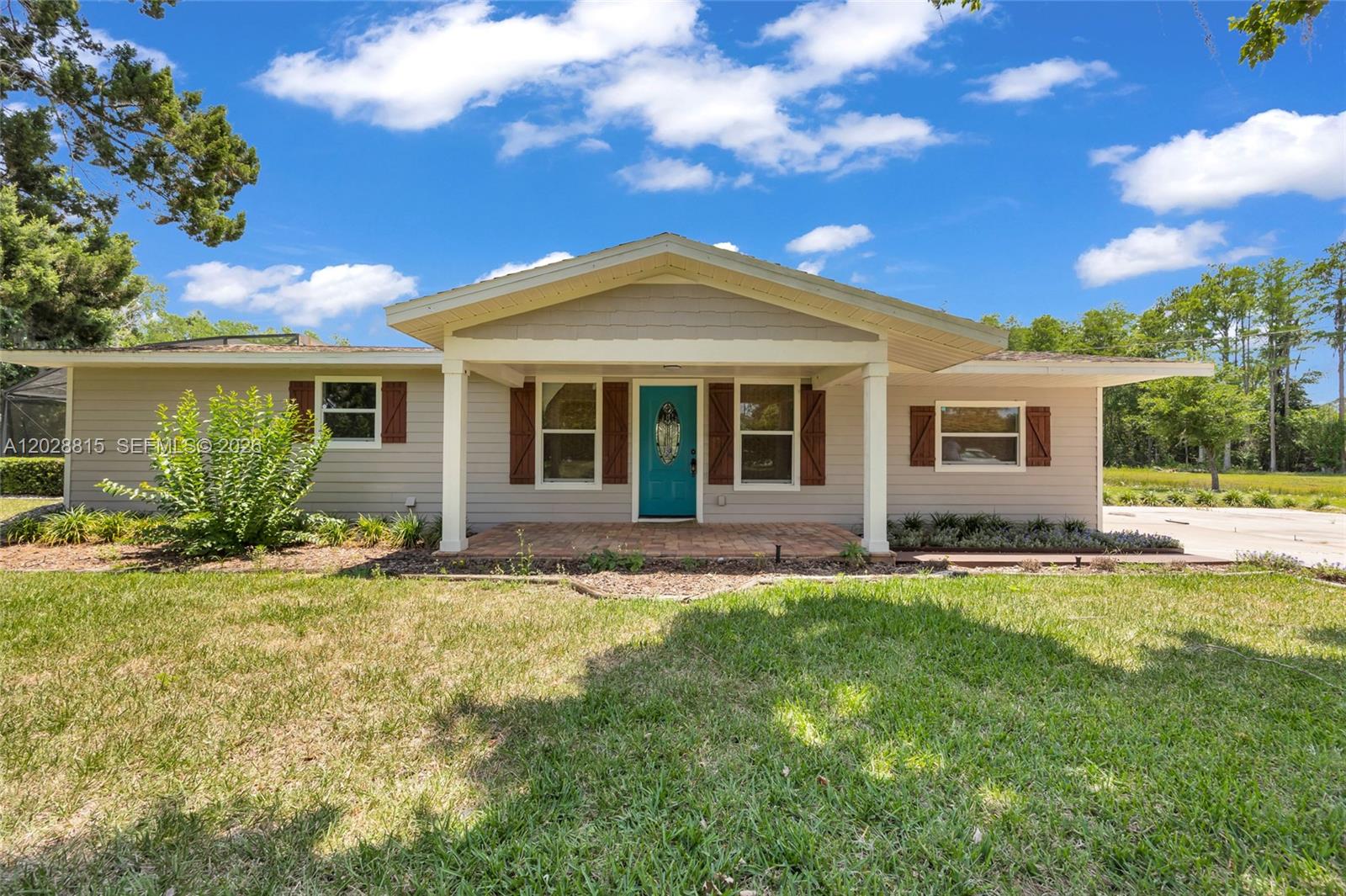 A single-story house with light gray siding, a teal front door, and a covered porch — 4125 rambler avenue, Saint Cloud FL 34772, SAINT CLOUD, FL