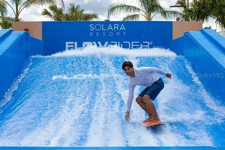 A young man surfs on a FlowRider wave machine at an outdoor resort — 1521 CAREY PALM CIRCLE, KISSIMMEE, FL