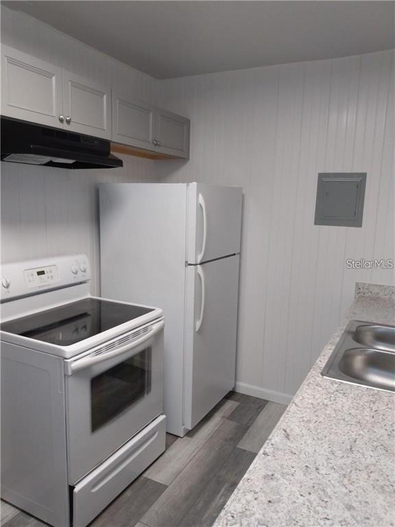 A kitchen features light gray cabinets, a white stove, a white refrigerator, and granite countertops — 110 ORANGE AVENUE, WINTER HAVEN, FL