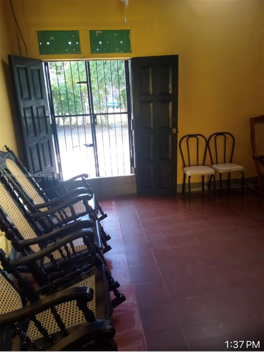 A room with yellow walls, tile floors, rocking chairs, and an open doorway with security bars — De la iglesia xalteva 2 C al sur 1/2 al lago, Gr, Gr