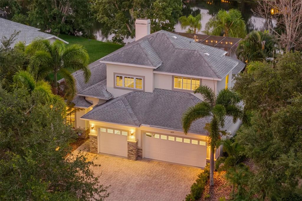 An aerial view of a two-story house with a three-car garage and a paved driveway — 6215 WARBLER LANE, LAKEWOOD RANCH, FL
