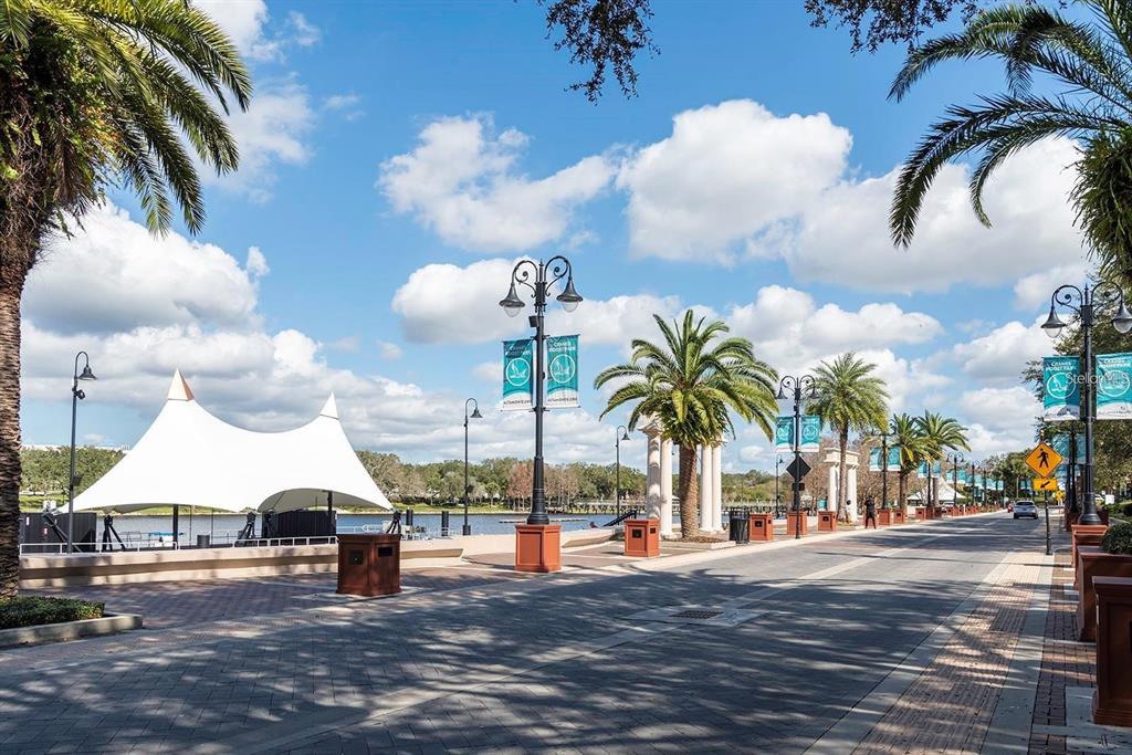 A paved waterfront promenade features palm trees, decorative street lamps, and a large white canopy — 120 BLUE POINTE WAY UNIT 340, ALTAMONTE SPRINGS, FL