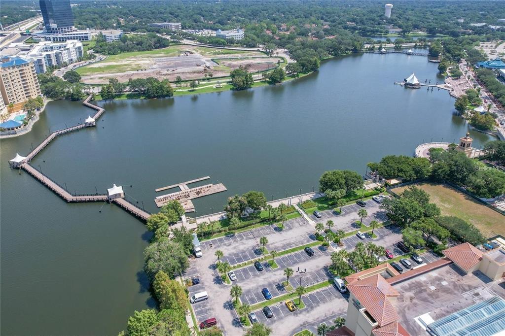 An aerial view shows a lake with a wooden pier, surrounding parking lots, and buildings — 120 BLUE POINTE WAY UNIT 340, ALTAMONTE SPRINGS, FL