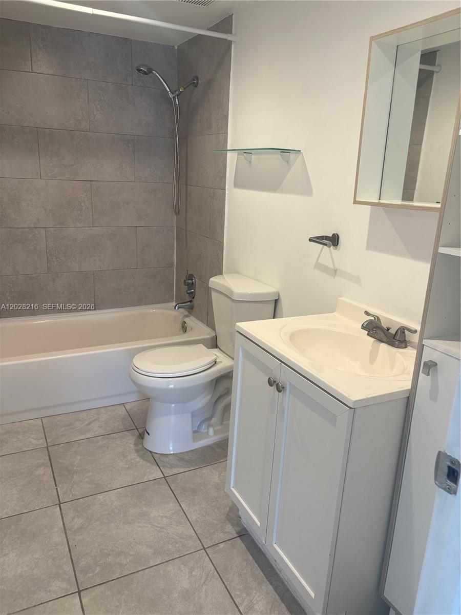 A bathroom features a tiled shower-tub combo, a white toilet, and a vanity with sink — 2000 NE 135th St # 208, North Miami FL 33181, NORTH MIAMI, FL