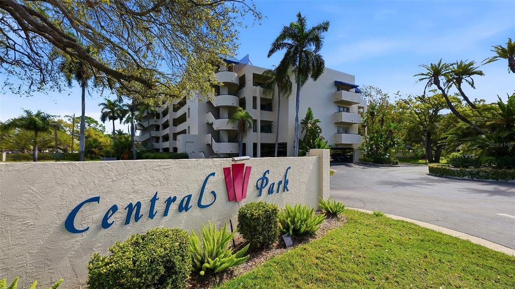 A beige multi-story apartment building stands behind a sign reading Central Park — 825 S OSPREY AVENUE UNIT 101, SARASOTA, FL