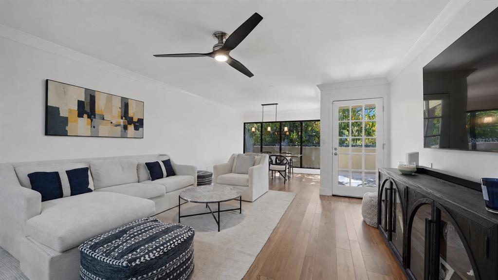 A living room features a white sectional sofa, a marble coffee table, and wood flooring — 825 S OSPREY AVENUE UNIT 101, SARASOTA, FL