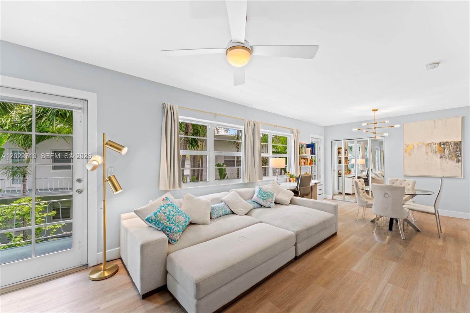 A living room features a sectional sofa, dining area, and a glass door to a balcony — 1925 Washington Ave # 16, Miami Beach FL 33139, MIAMI BEACH, FL