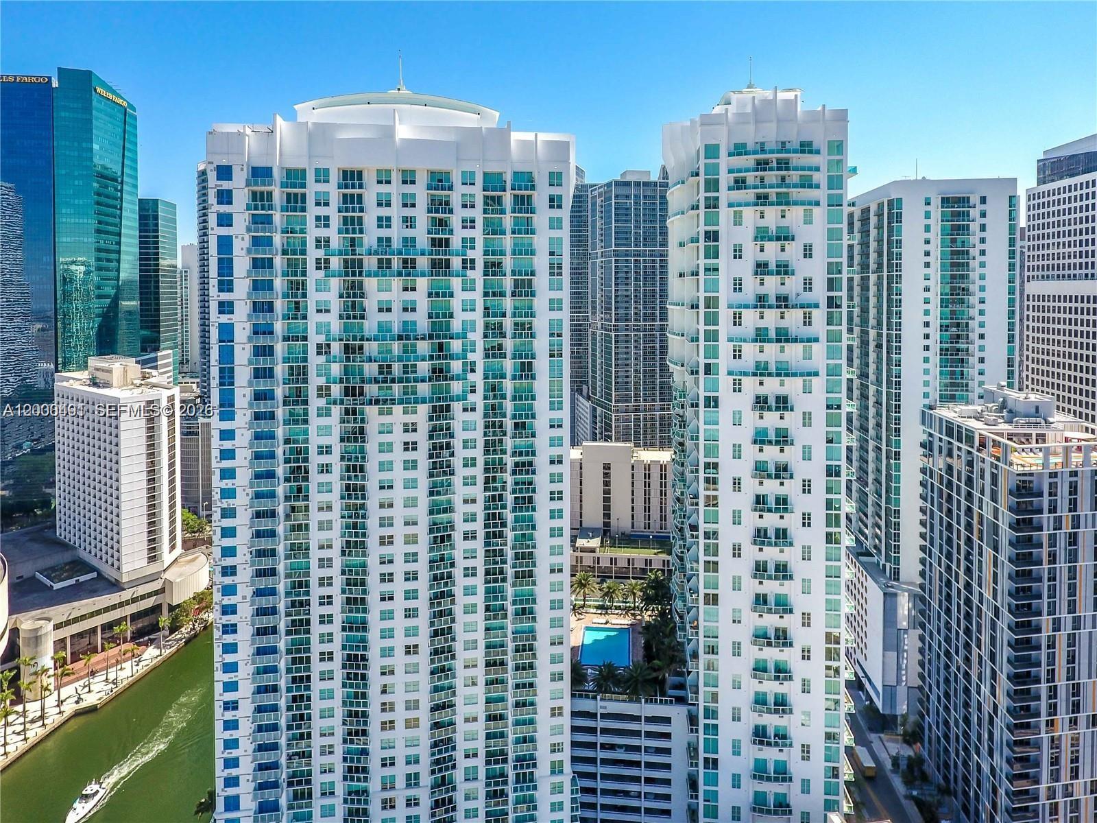 An aerial view of several tall white residential skyscrapers in a dense urban city — 31 SE 5th St # 4212, Miami FL 33131, MIAMI, FL