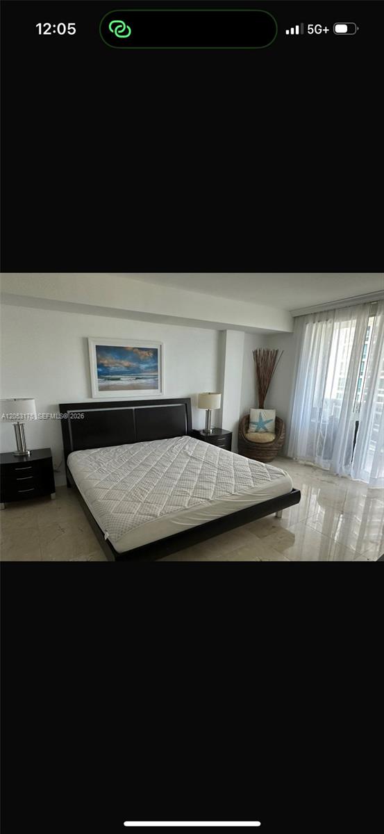 A bedroom features a dark wood bed frame, two nightstands, and a large window with curtains — 10275 Collins Ave # 808, Bal Harbour FL 33154, BAL HARBOUR, FL