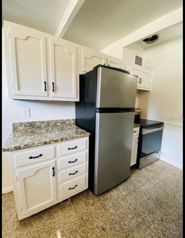 A kitchen features white cabinets, granite countertops, and stainless steel appliances — 3207 CLIFFORD SAMPLE DRIVE, TAMPA, FL