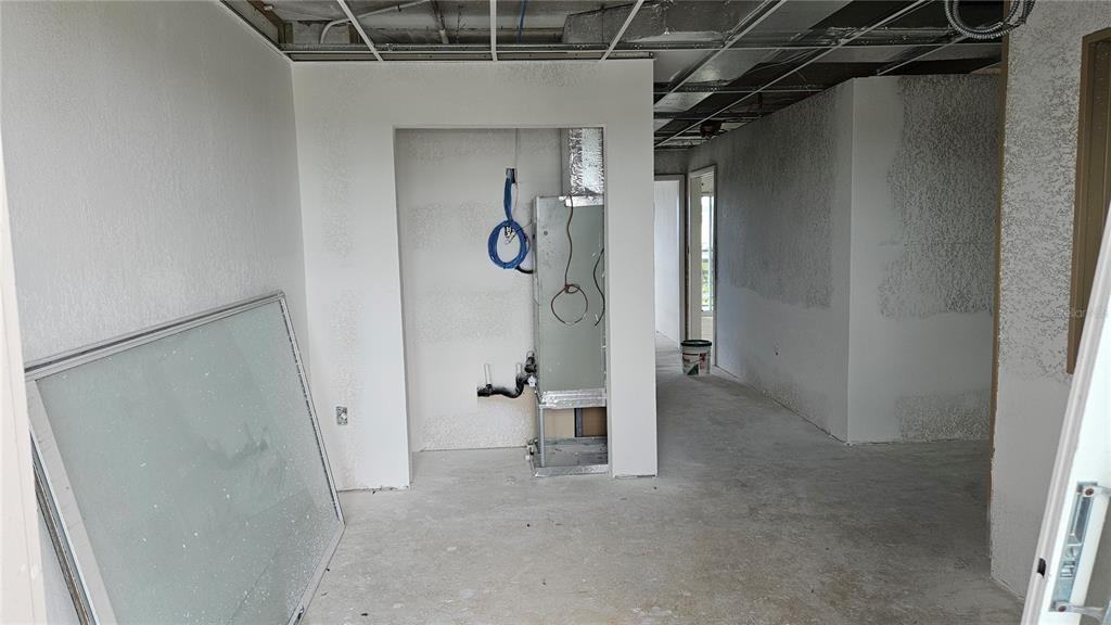 An unfinished interior space features an exposed HVAC unit, bare concrete floors, and ceiling framing — 1460 S MCCALL ROAD UNIT H3, ENGLEWOOD, FL