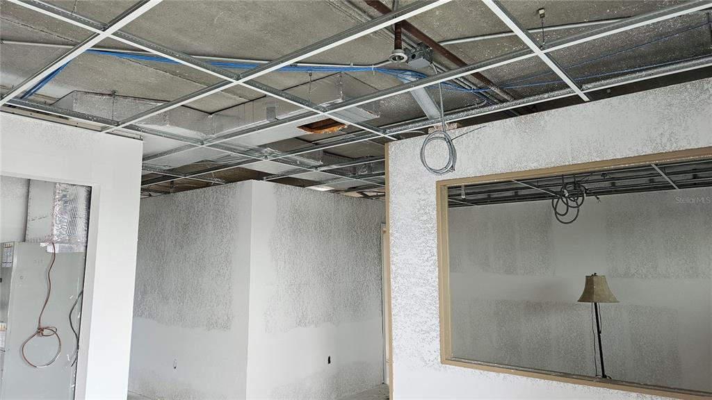 An unfinished commercial interior space features exposed ceiling grids, drywall partitions, and a window opening — 1460 S MCCALL ROAD UNIT H3, ENGLEWOOD, FL