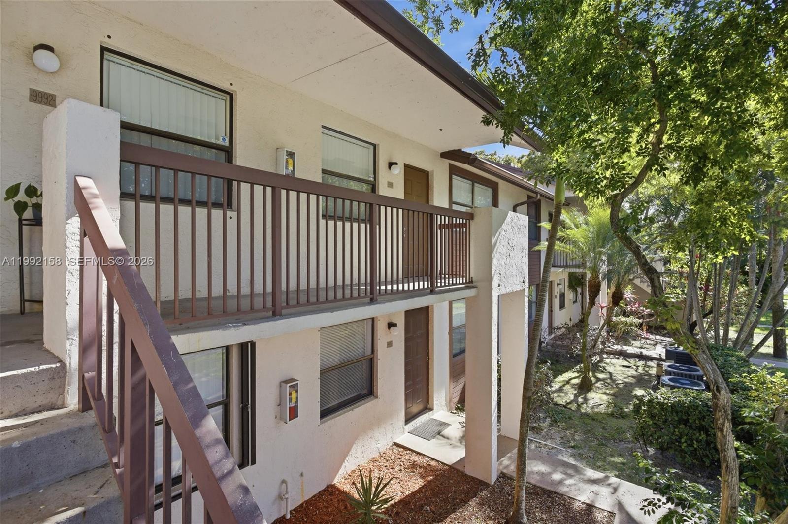 An exterior view of a two-story apartment building with a balcony and outdoor staircase — 9994 Nob Hill Ct # 9994, Sunrise FL 33351, SUNRISE, FL