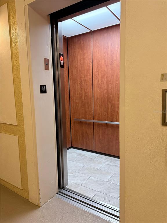 An elevator with wood-paneled walls and a tiled floor opens into a hallway — 3338 ROBERT TRENT JONES DRIVE UNIT 20104, ORLANDO, FL
