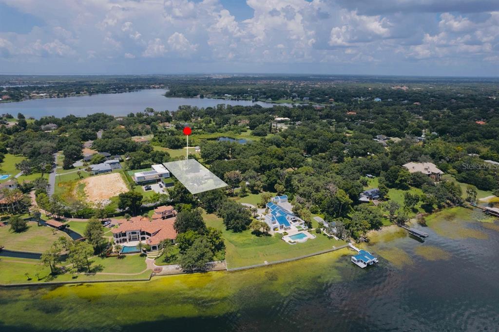 An aerial view shows a waterfront property with a highlighted lot and surrounding residential homes — 11923 LAKE BUTLER BOULEVARD, WINDERMERE, FL