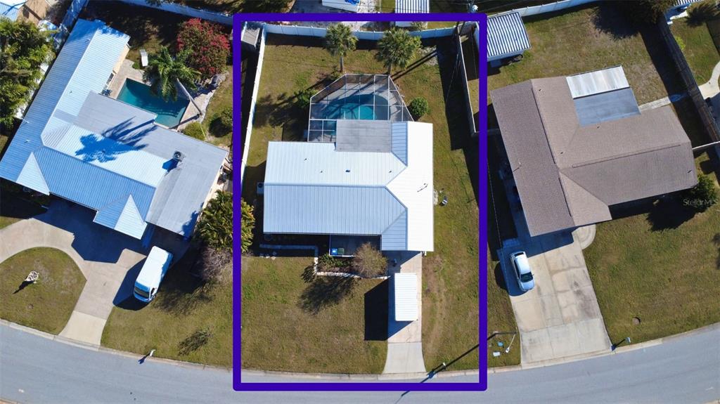 An aerial view shows a house with a metal roof and a screened-in pool — 2534 WANETA DRIVE, SARASOTA, FL