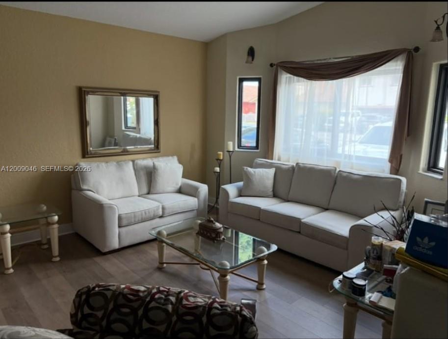 A living room features two white sofas, a glass coffee table, and a large window — 8741 NW 141st Ter, Miami Lakes FL 33018, MIAMI LAKES, FL