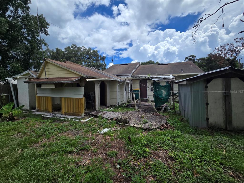 The exterior of a house features a wooden deck, a shed, and a covered porch area — 2714 SAMPLE STREET, KISSIMMEE, FL