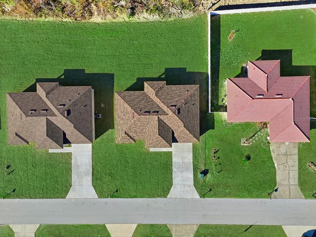 A single-story house with a white stucco exterior, a dark garage door, and a driveway — 4443 SW 152ND STREET, OCALA, FL