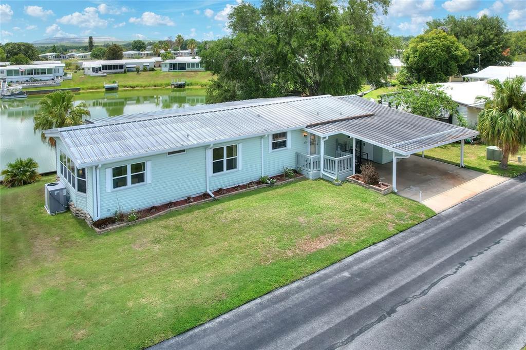 An aerial view shows a light green mobile home with a metal roof and carport — 2055 S FLORAL AVENUE UNIT 262, BARTOW, FL