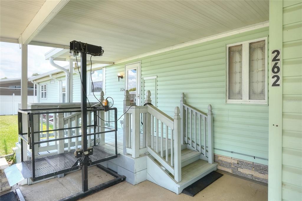 A light green house exterior features a wheelchair lift beside a small wooden staircase — 2055 S FLORAL AVENUE UNIT 262, BARTOW, FL