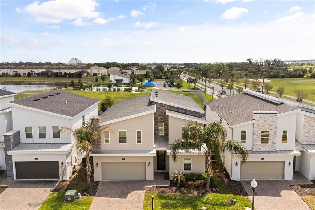 An aerial view shows three modern two-story houses with attached garages and paved driveways — 917 OCEAN COURSE AVENUE, DAVENPORT, FL