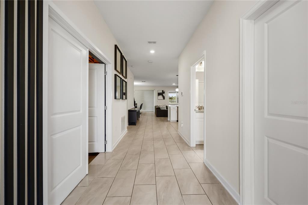 A tiled hallway leads from the foreground toward an open-concept living area and kitchen — 917 OCEAN COURSE AVENUE, DAVENPORT, FL