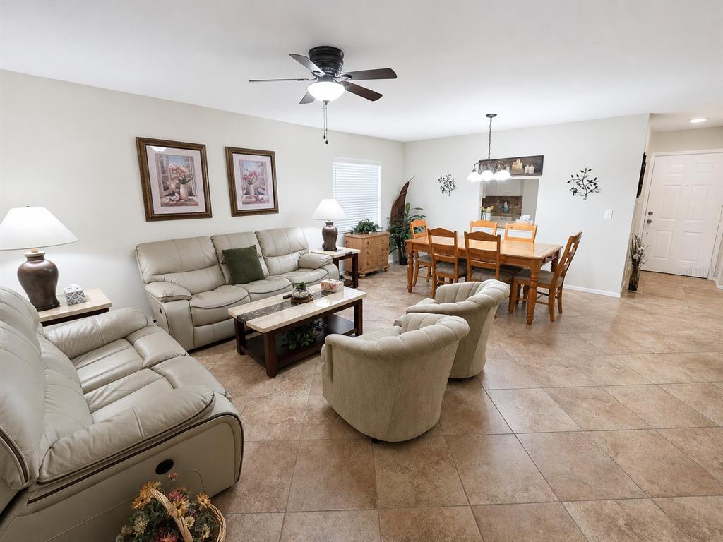 An open-concept living and dining area features tile flooring, neutral walls, and a ceiling fan — 225 OAK HILL DRIVE UNIT 10, SARASOTA, FL