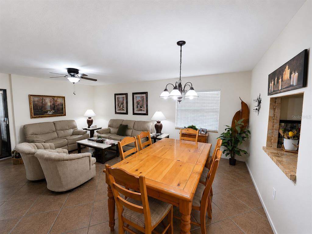 A dining area with a wooden table and chairs sits adjacent to a living room — 225 OAK HILL DRIVE UNIT 10, SARASOTA, FL