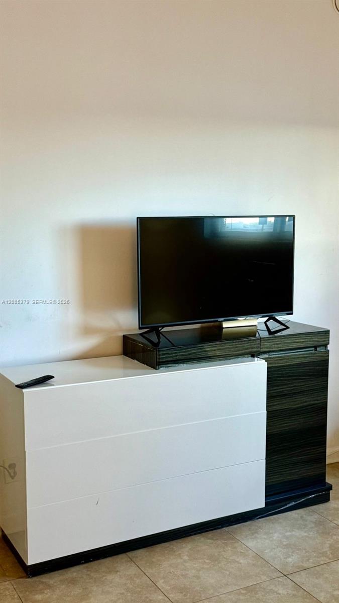 A flat-screen television sits on a two-toned white and dark wood media console — 4001 S Ocean Dr, Hollywood FL 33019, HOLLYWOOD, FL