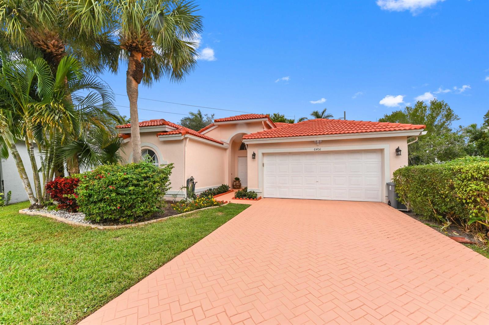 A single-story peach-colored house features a red tile roof and a paved driveway — 6451 Tiara Drive, Boynton Beach FL 33437, BOYNTON BEACH, FL
