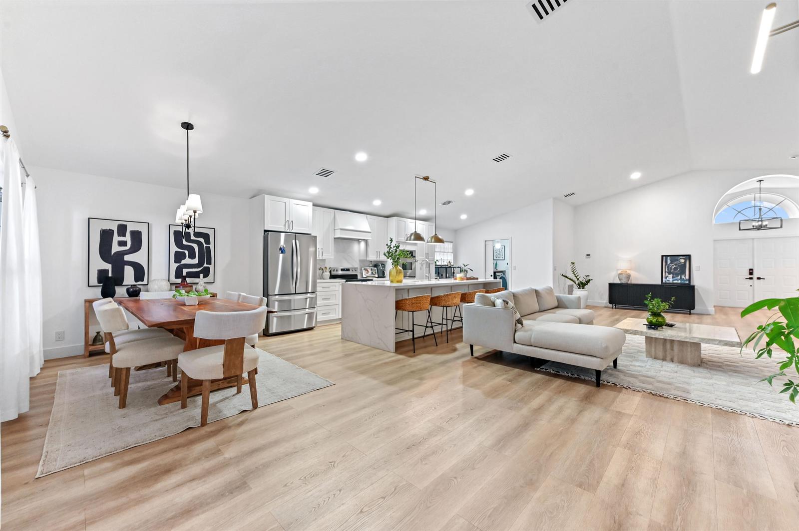 An open-concept living area features a kitchen with a marble island, dining space, and sofa — 6451 Tiara Drive, Boynton Beach FL 33437, BOYNTON BEACH, FL