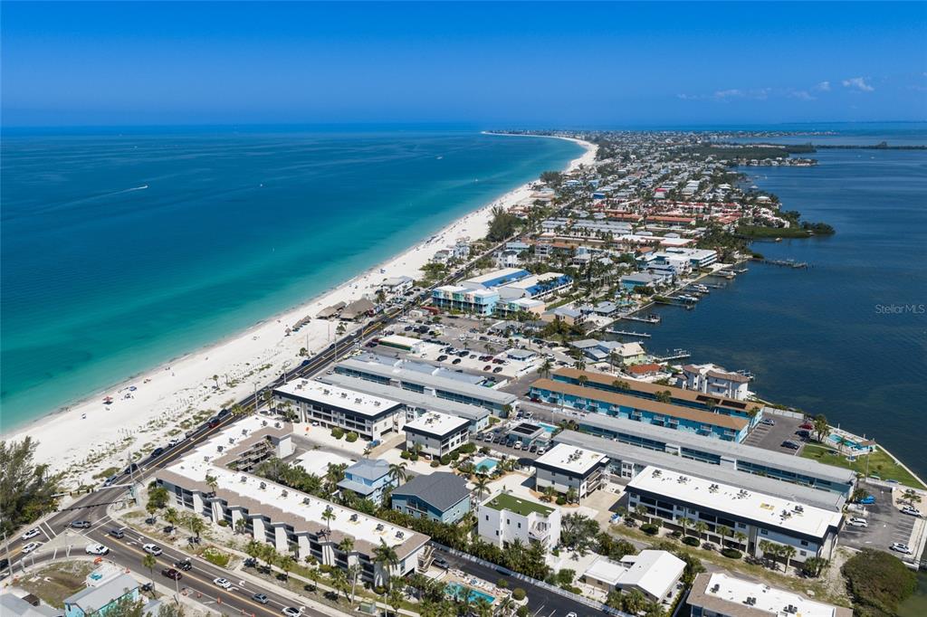 An aerial view shows a coastal town with a beach, ocean, and bay — 109 6TH STREET N UNIT A, BRADENTON BEACH, FL