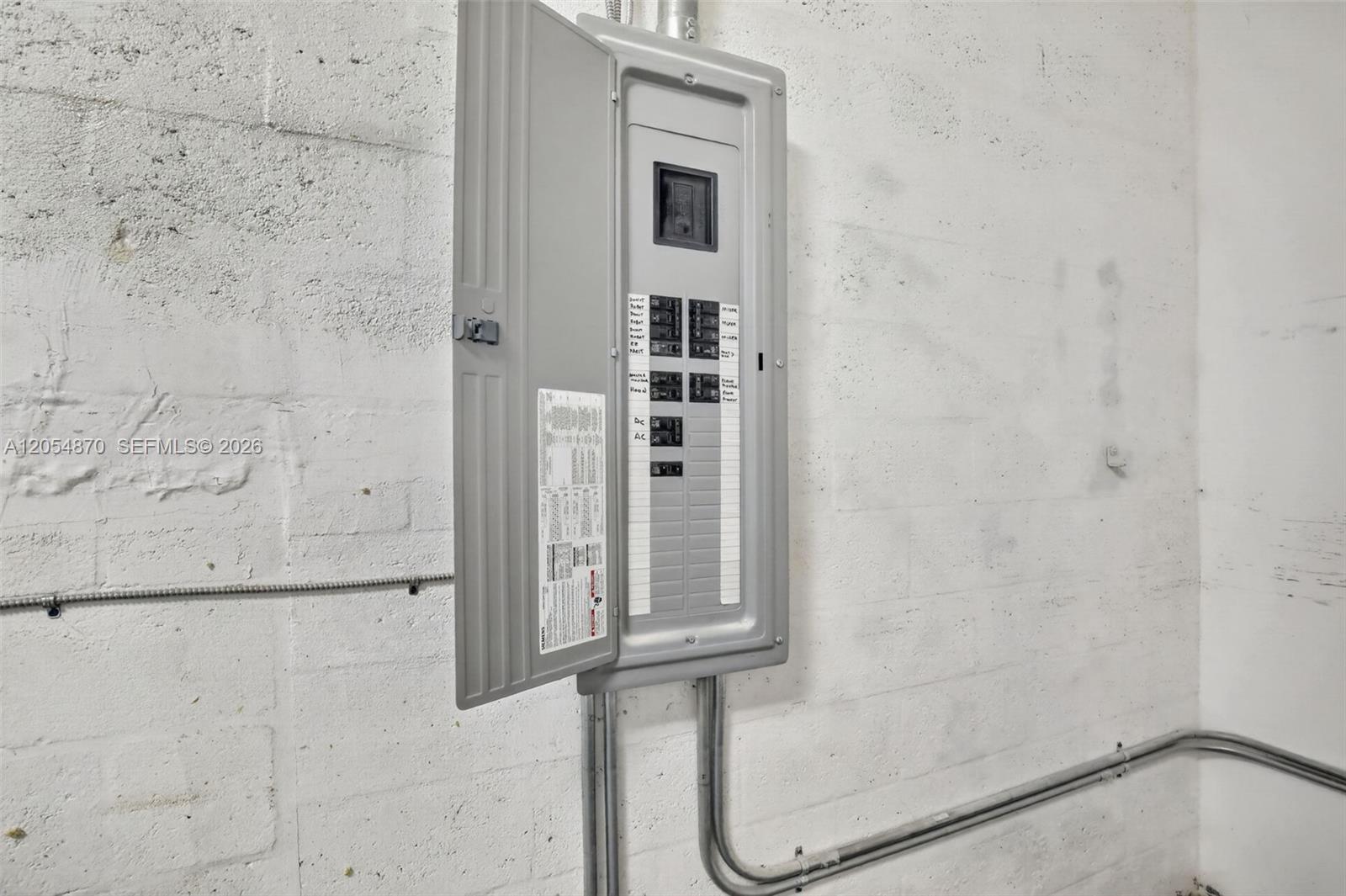 A gray electrical breaker panel is mounted on a white painted concrete block wall — 2027 Sherman St # B, Hollywood FL 33020, HOLLYWOOD, FL