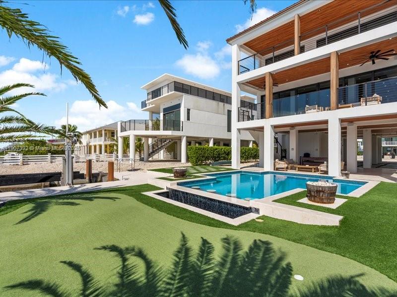 A multi-story waterfront home features a swimming pool, putting green, and elevated balconies — 239 Tavernier Dr, Tavernier FL 33070, TAVERNIER, FL
