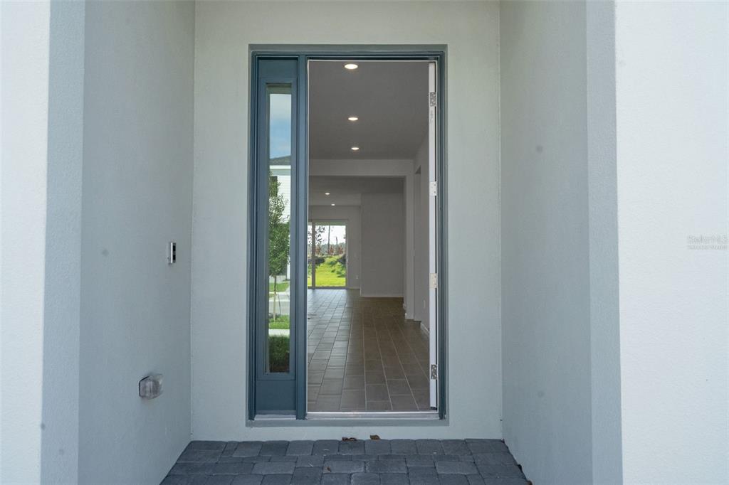 A gray front door with a side light opens into a tiled entryway — 5412 NW CAMBERLY COURT, PORT ST LUCIE, FL