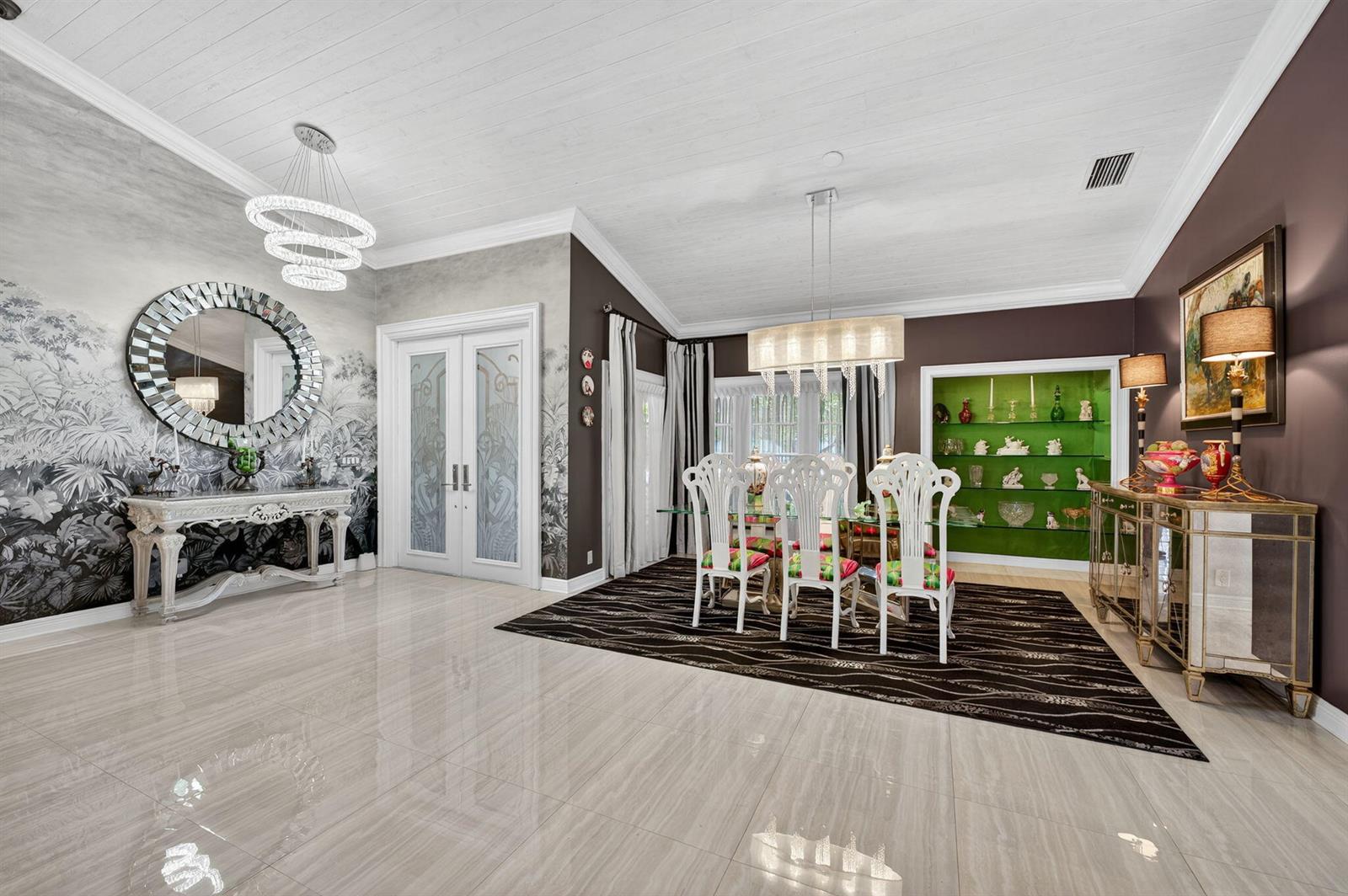 A dining room features a glass table, white chairs, a green display niche, and wallpaper — 7205 Mandarin Drive, Boca Raton FL 33433, BOCA RATON, FL