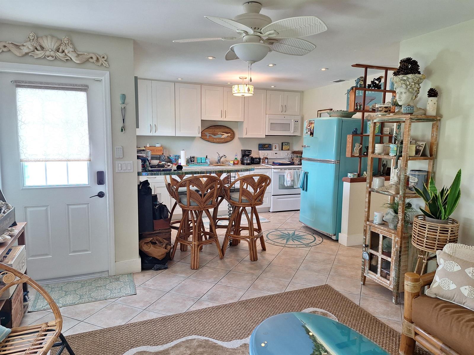 A kitchen with white cabinets, a light blue refrigerator, and a breakfast bar with stools — 217 SE 2nd Avenue, Boynton Beach FL 33435, BOYNTON BEACH, FL