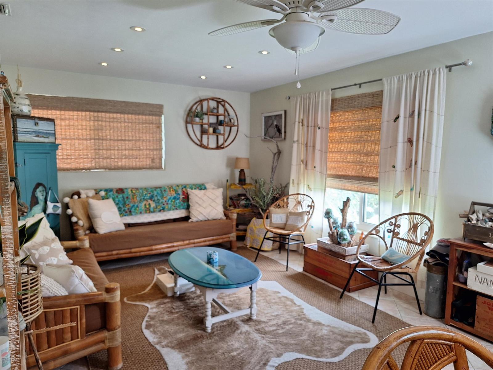 A living room features bamboo furniture, a blue coffee table, and a cowhide rug — 217 SE 2nd Avenue, Boynton Beach FL 33435, BOYNTON BEACH, FL