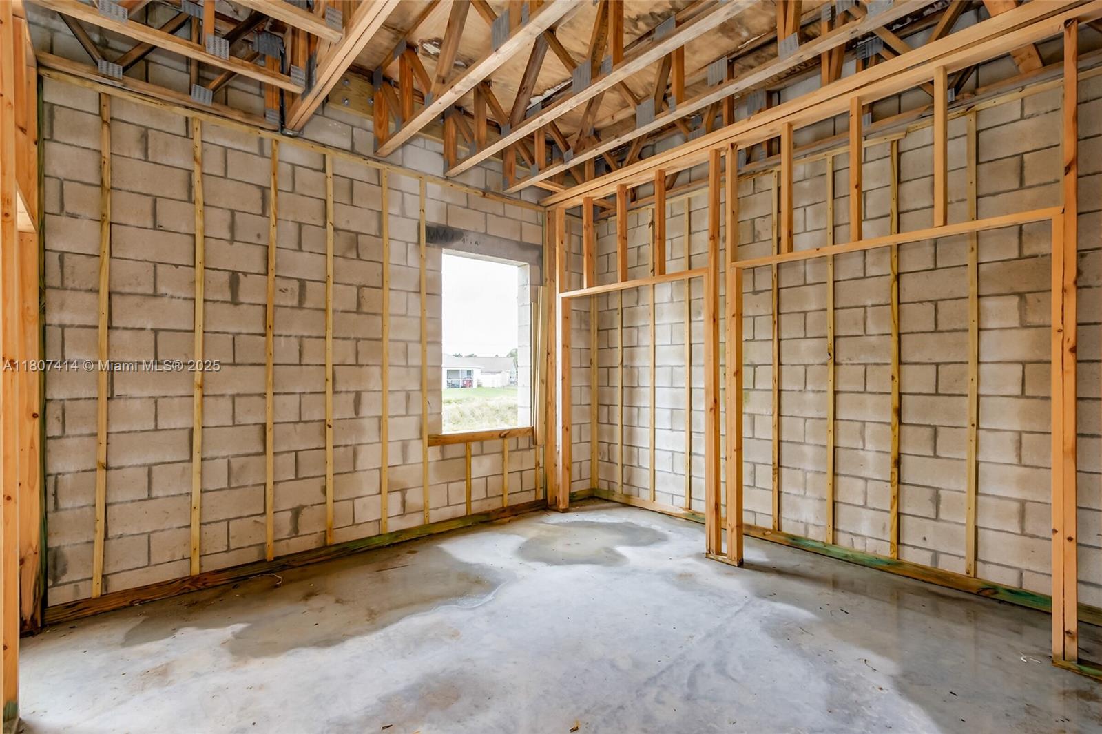 An unfinished room features concrete block walls, exposed wood framing, and a concrete floor — 2826 2830 HESTER AVE, Palm Bay FL 32909, PALM BAY, FL