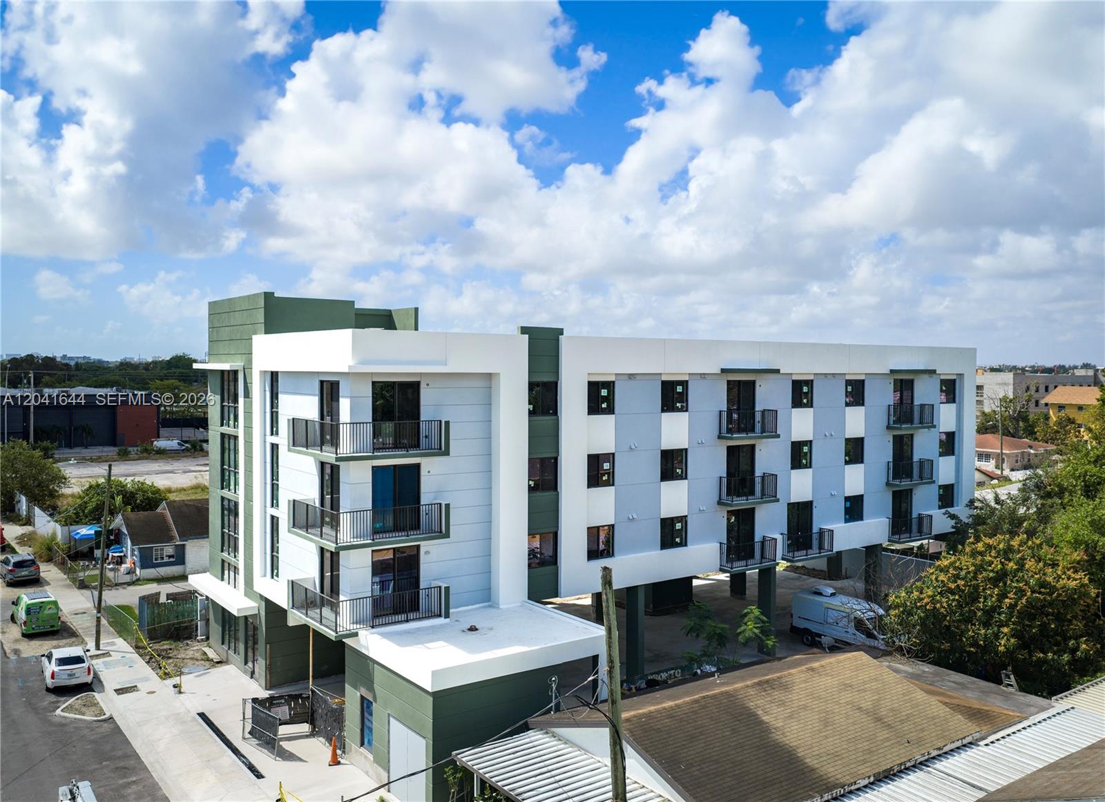 An exterior view of a modern, multi-story apartment building with balconies and a ground-level parking area — 37XX NW 23 Ave # 16, Miami FL 33142, MIAMI, FL