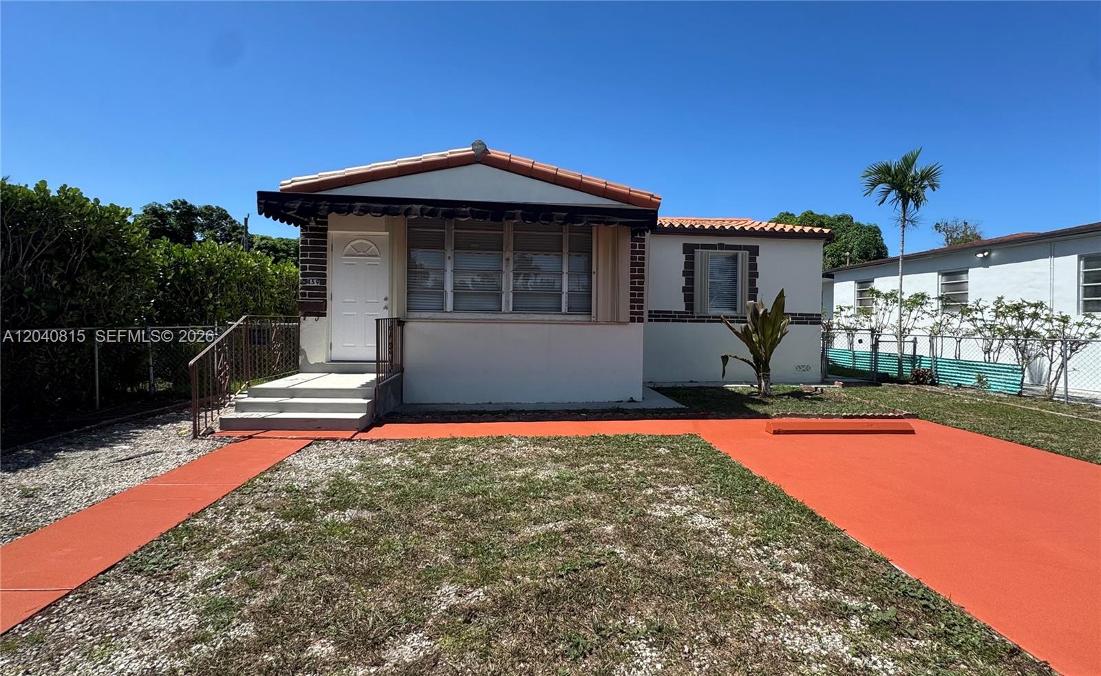 A single-story house features a white exterior, a tiled roof, and a red-painted driveway — 459 SE 3rd St, Hialeah FL 33010, HIALEAH, FL