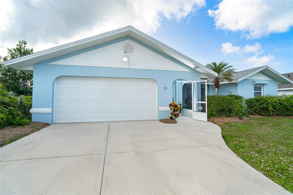 A light blue house with a two-car garage and a screened front entryway — 15 BUNKER PLACE, ROTONDA WEST, FL