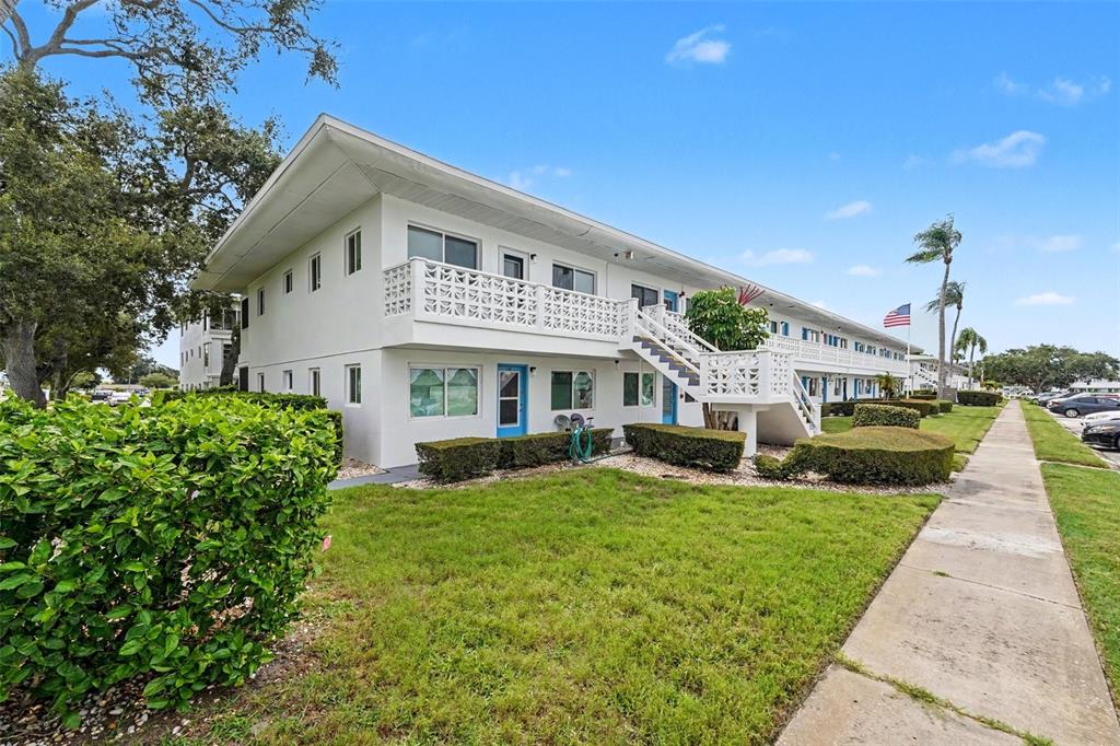 A two-story white apartment building with an exterior walkway and a lawn in front — 8555 112TH STREET N UNIT 204, SEMINOLE, FL