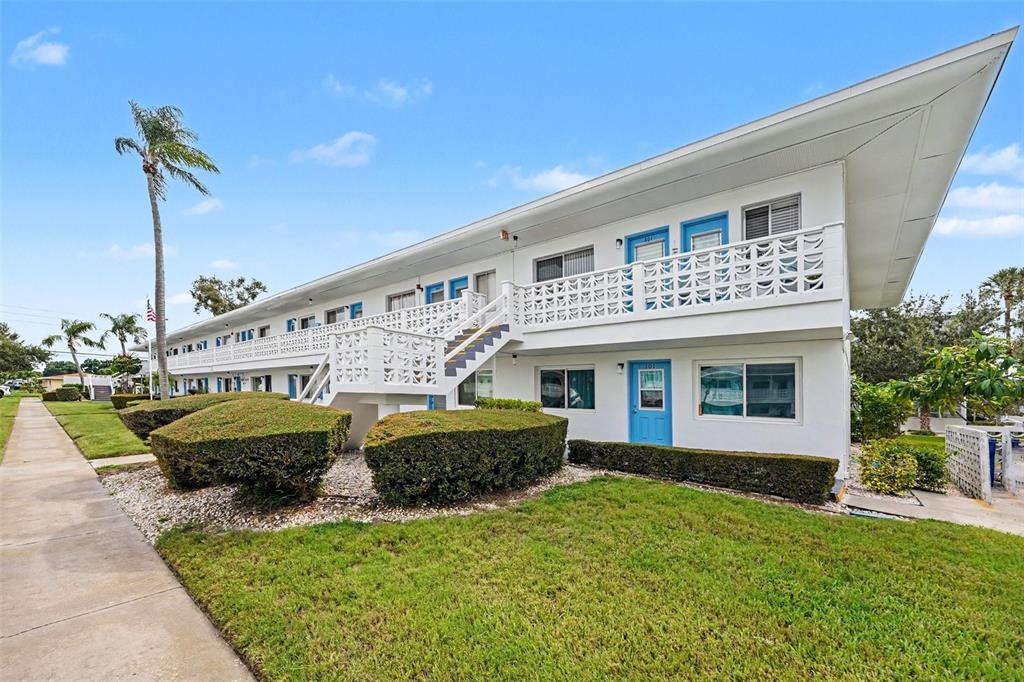 A two-story white apartment building with blue doors and a decorative concrete balcony railing — 8555 112TH STREET N UNIT 204, SEMINOLE, FL