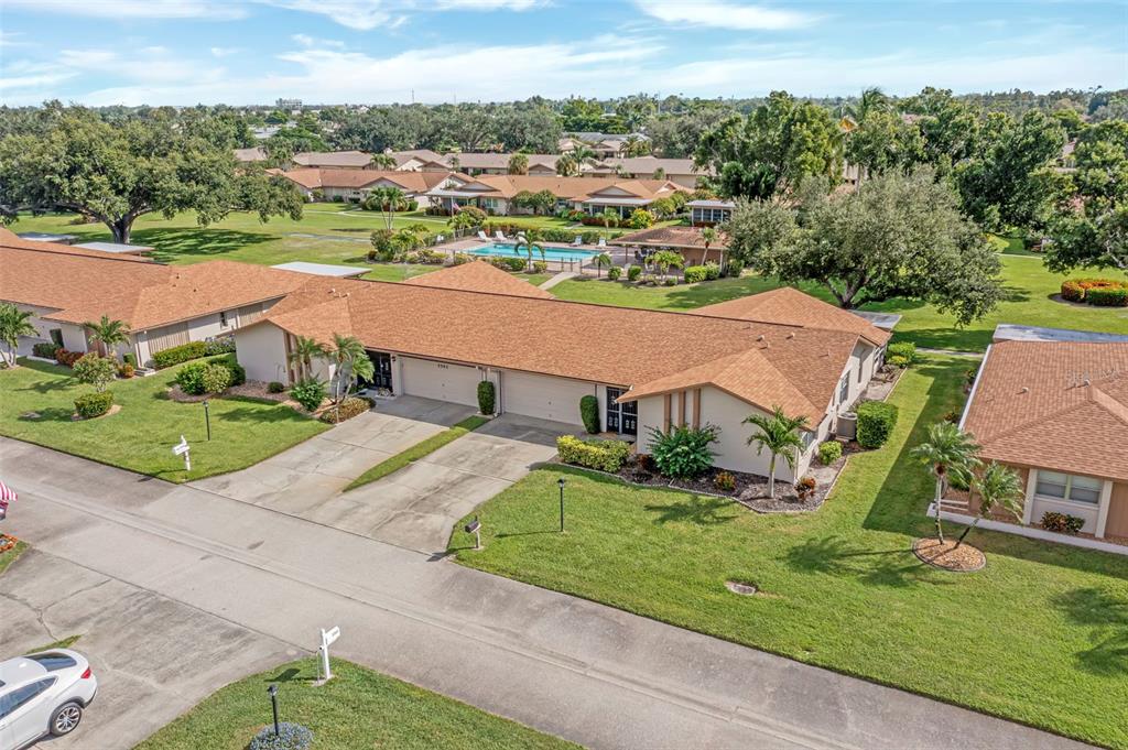 An aerial view shows a single-story residential building with a brown roof and attached garages — 5584 BURING COURT, FORT MYERS, FL