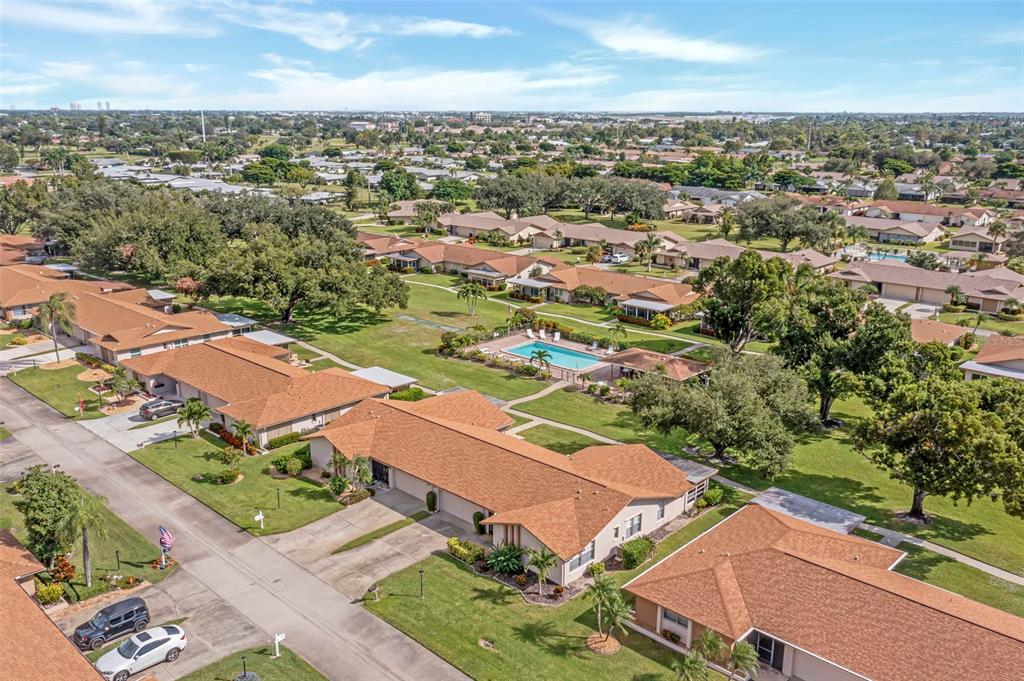 An aerial view of a residential neighborhood featuring single-story homes, a swimming pool, and landscaping — 5584 BURING COURT, FORT MYERS, FL