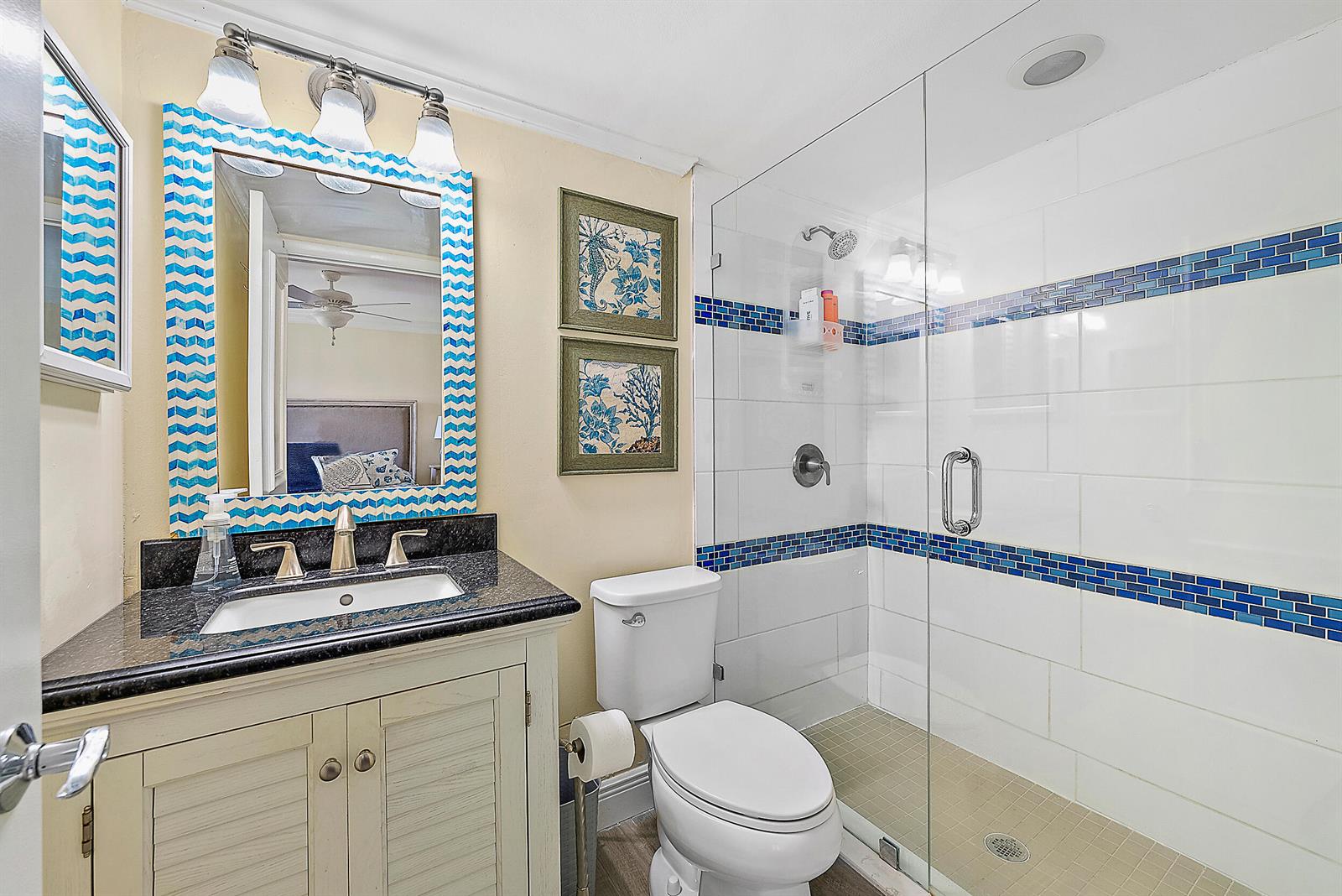 A bathroom features a vanity with a dark countertop, a toilet, and a glass-enclosed shower — 1605 S Us Highway 1, Jupiter FL 33477, JUPITER, FL